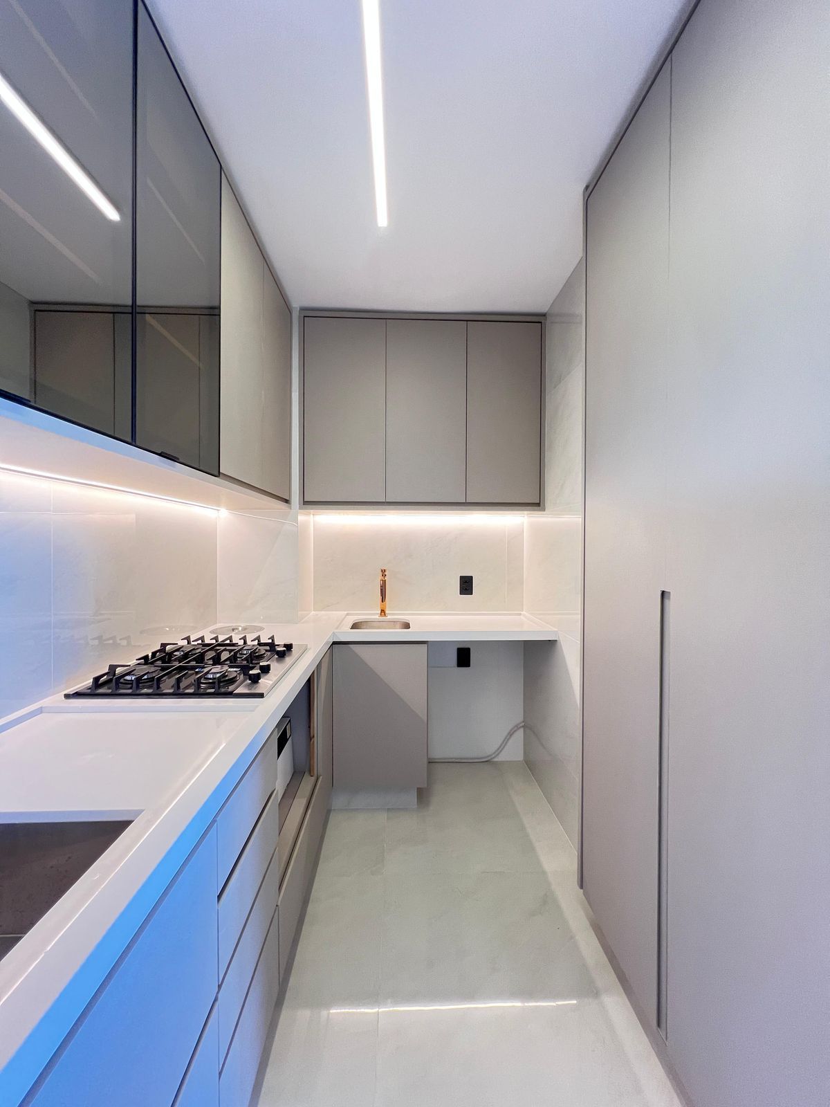 Cozinha com armários em madeira natural, bancada de concreto queimado e pendentes industriais, criando um espaço rústico e moderno.