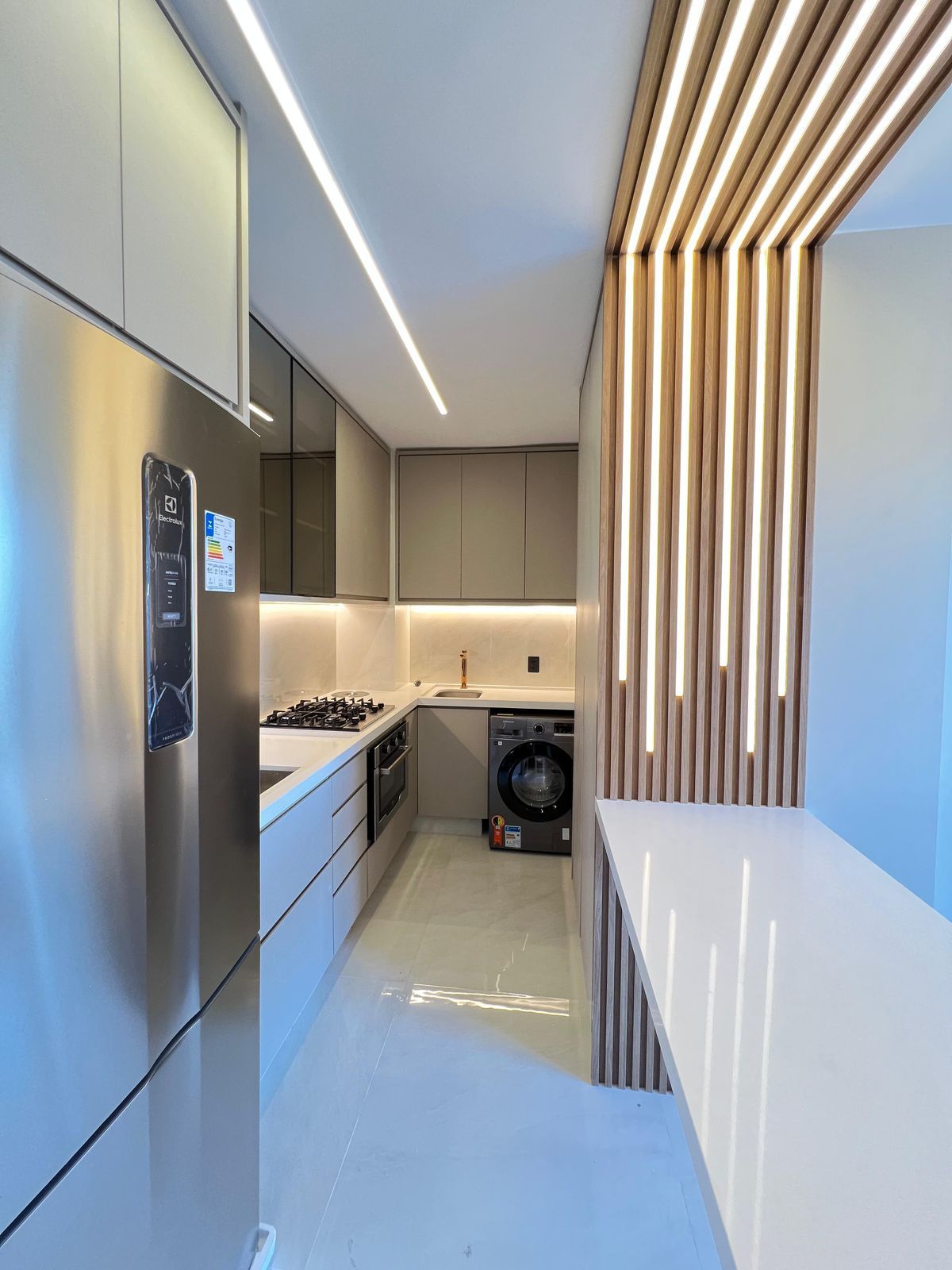 Cozinha com armários em dois tons, bancada espaçosa e um layout que facilita o fluxo de trabalho e a organização.