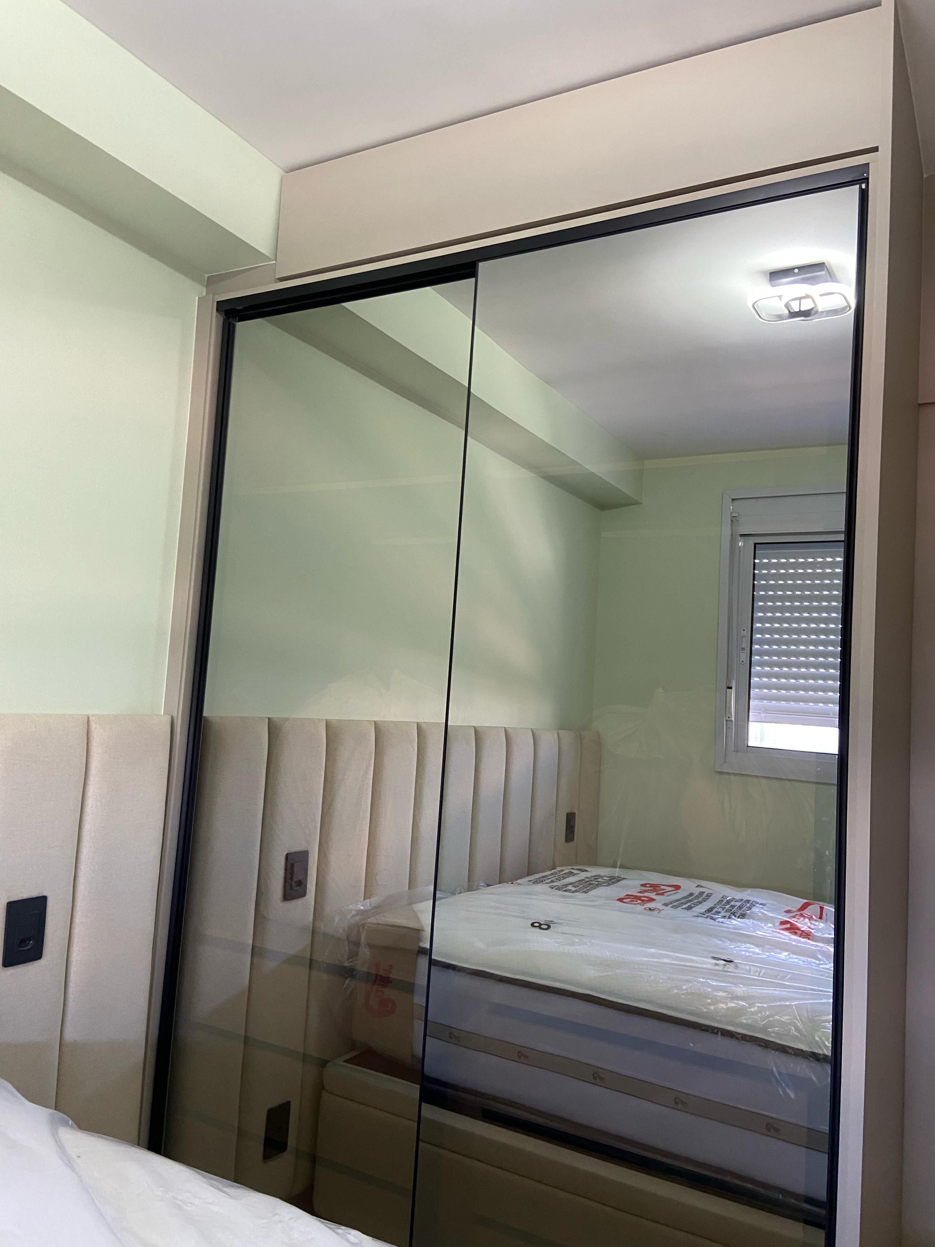 Quarto planejado com armários embutidos, cama confortável e detalhes em madeira, proporcionando funcionalidade e estilo.