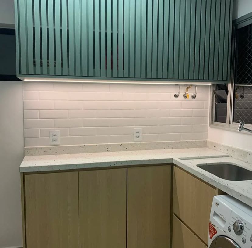 Cozinha planejada com ilha central que serve como área de preparo e mesa de jantar, otimizando a funcionalidade.