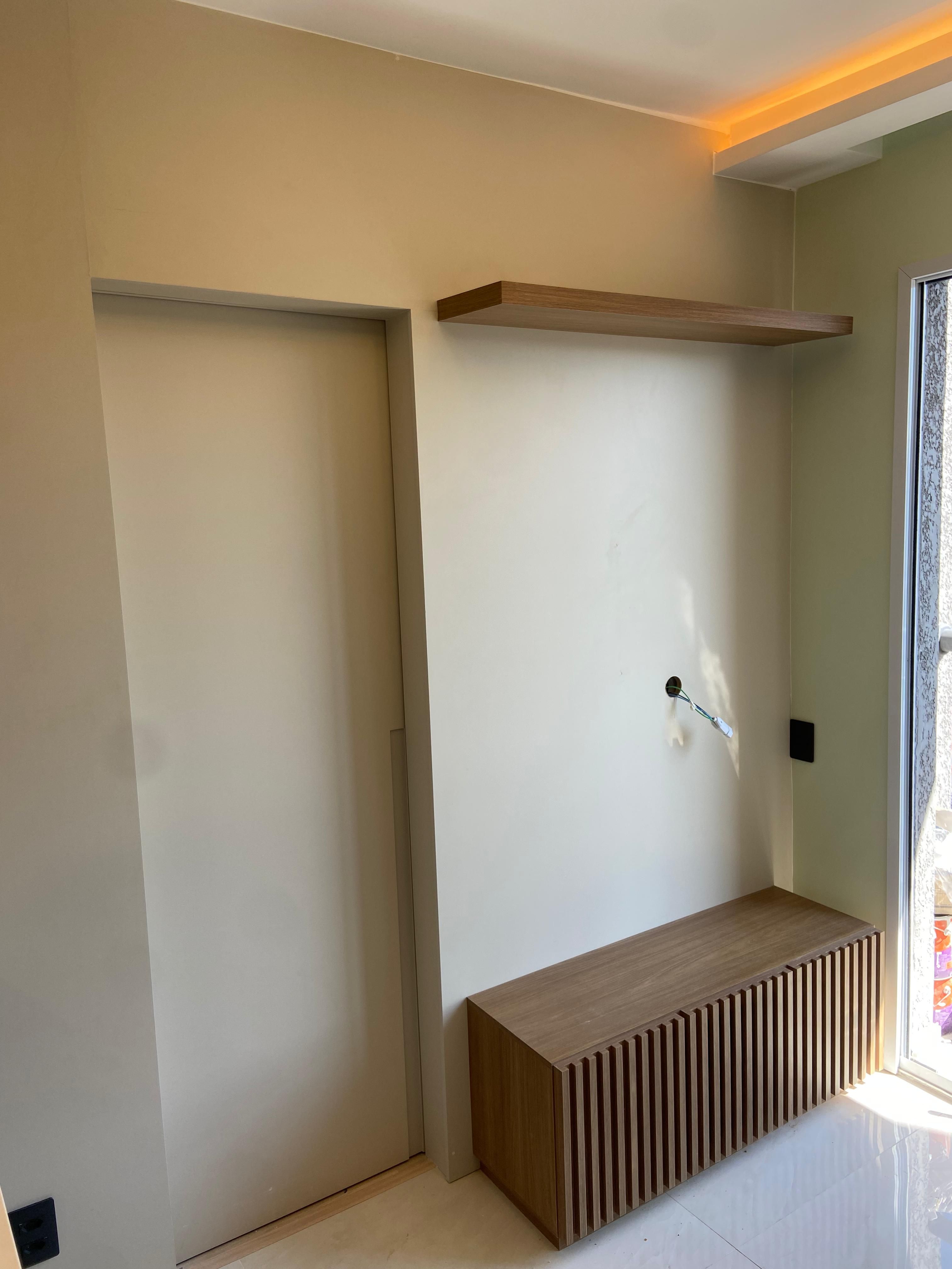 Sala de estar contemporânea com móveis em tons neutros, tapete texturizado e obras de arte na parede, criando um ambiente sofisticado.