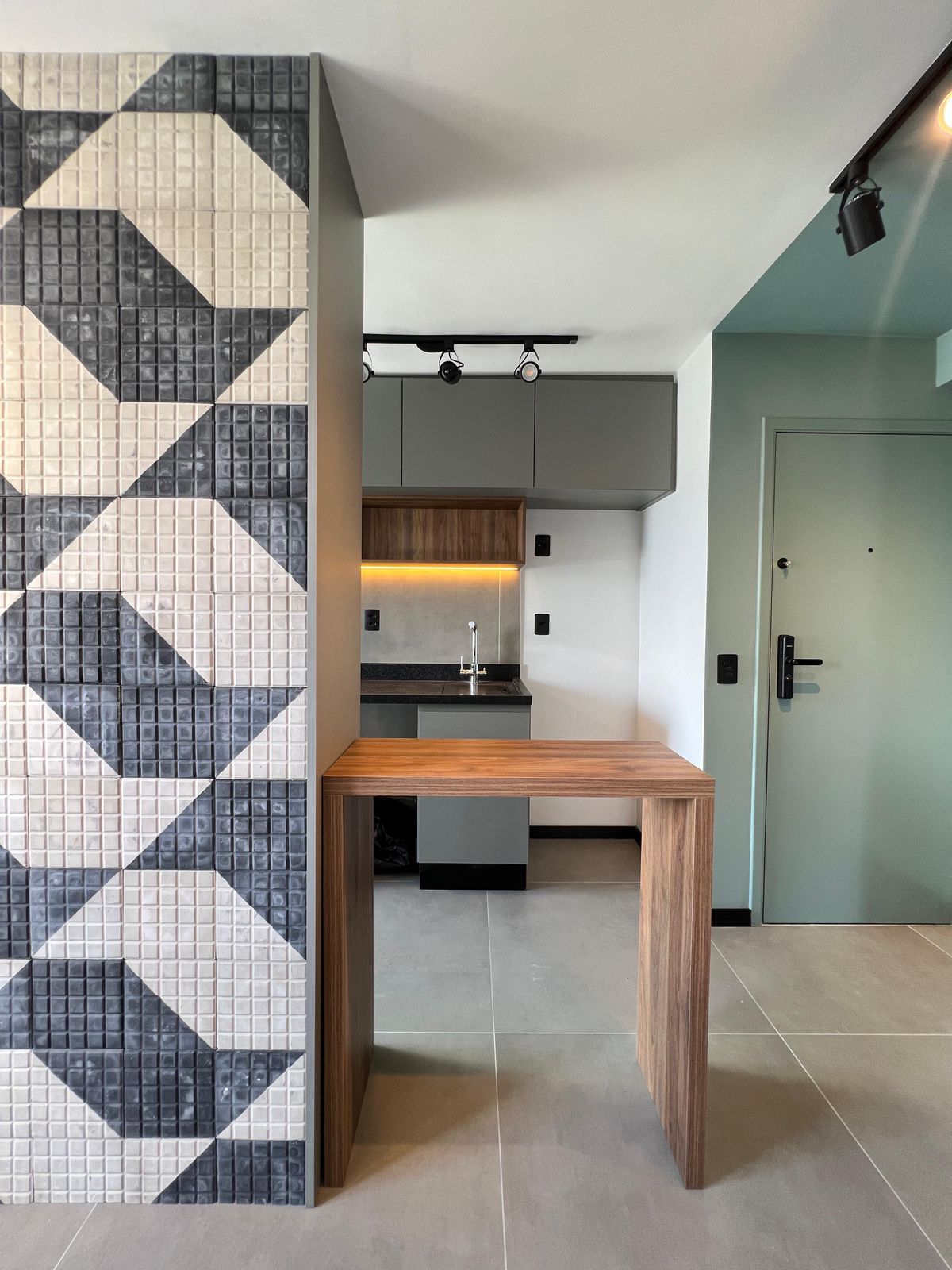 Cozinha com design contemporâneo, armários brancos, ilha central e detalhes em madeira, otimizando o espaço e a funcionalidade.