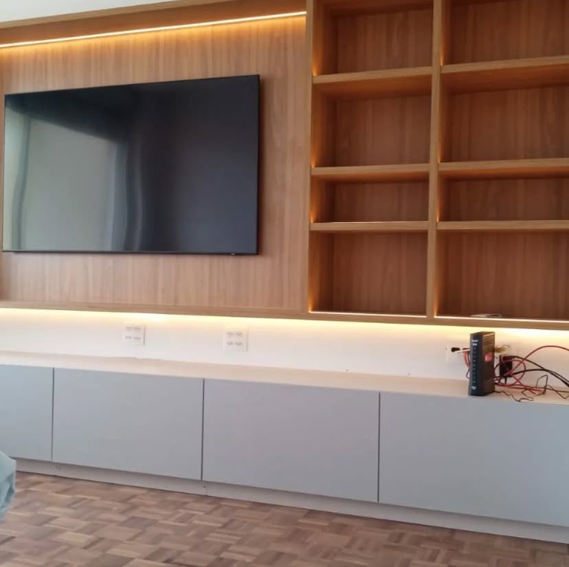 Sala de estar com design escandinavo, apresentando móveis de madeira clara, plantas verdes e uma atmosfera leve e arejada.