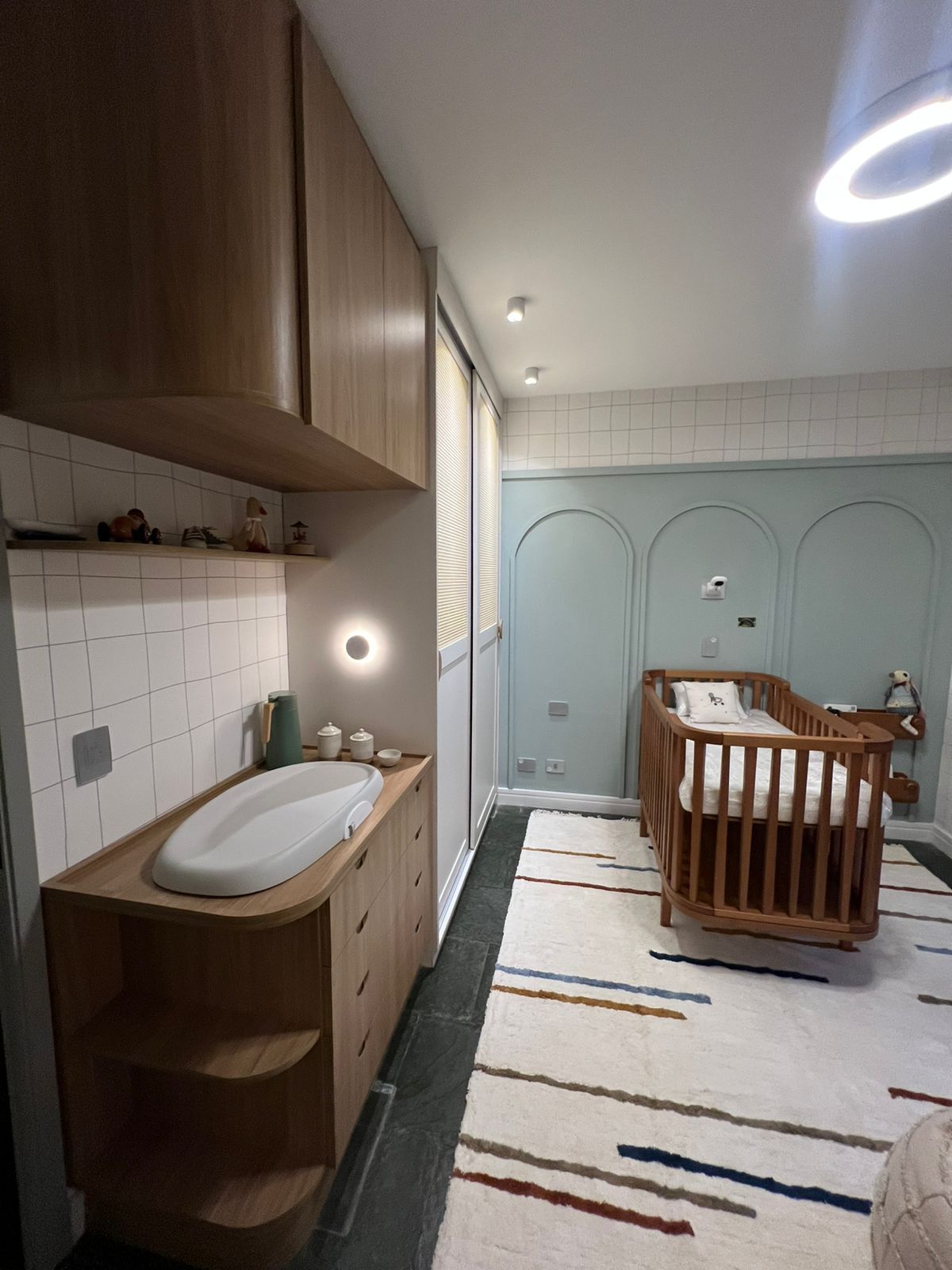 Quarto infantil planejado com cama baixa, prateleiras coloridas e decoração lúdica.