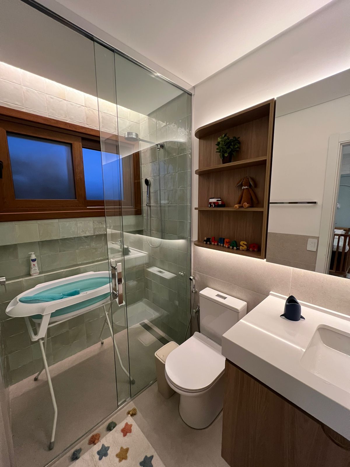 Banheiro contemporâneo com box de vidro, pia suspensa e azulejos texturizados, criando um ambiente moderno e estiloso.