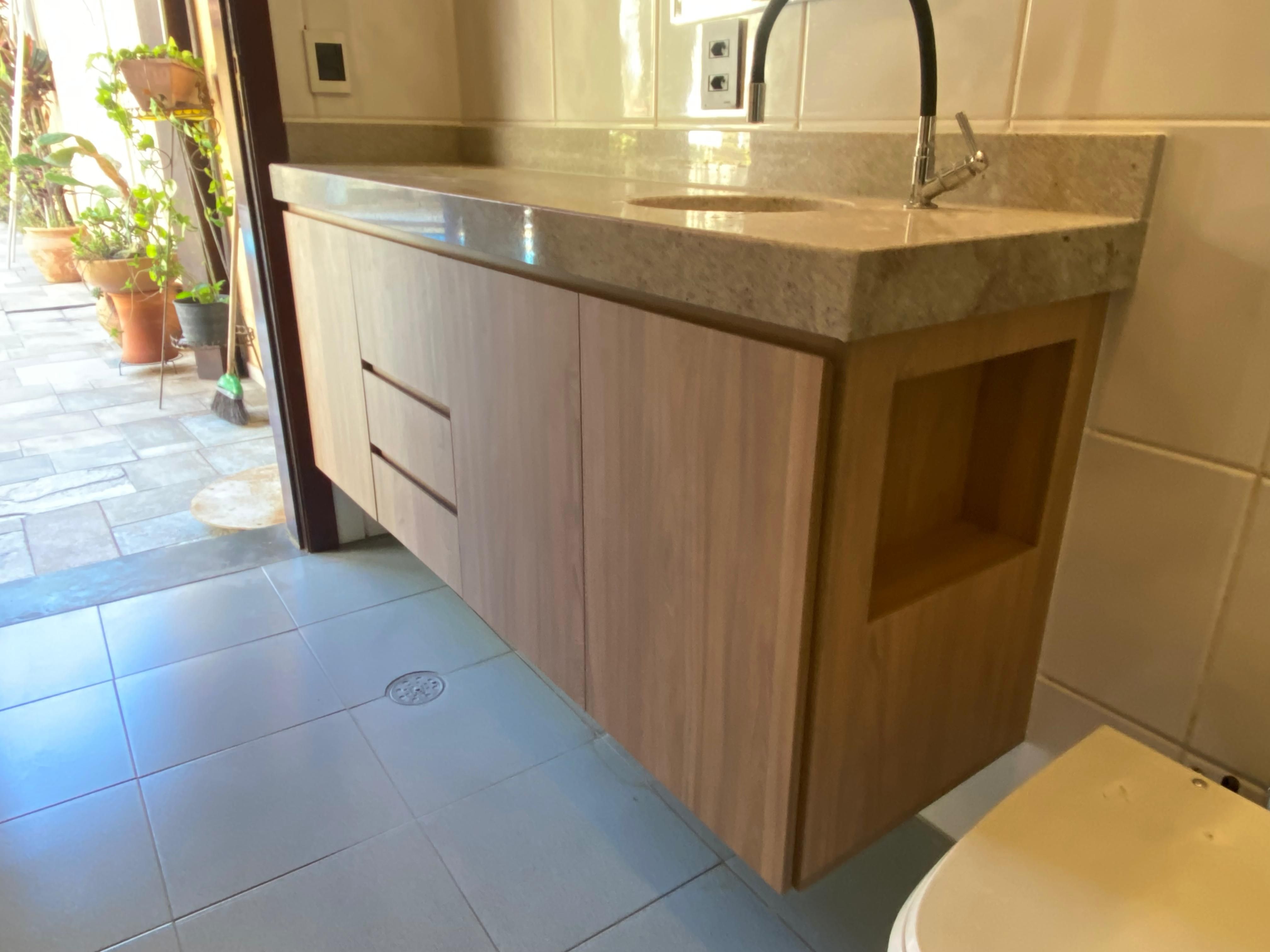 Banheiro elegante com detalhes em preto e branco, espelho redondo e iluminação de destaque, proporcionando um visual sofisticado.