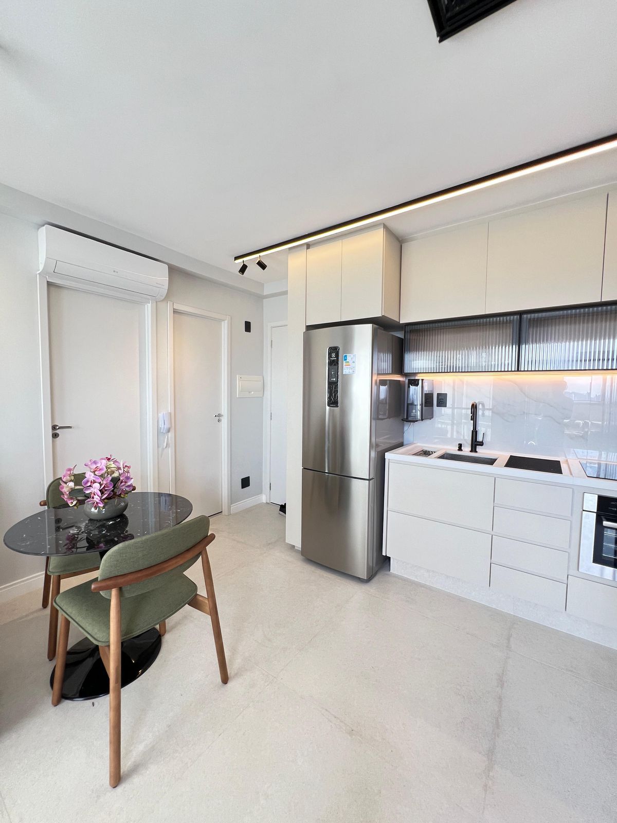 Cozinha compacta e funcional, com marcenaria inteligente, aproveitando cada centímetro com soluções criativas de armazenamento.