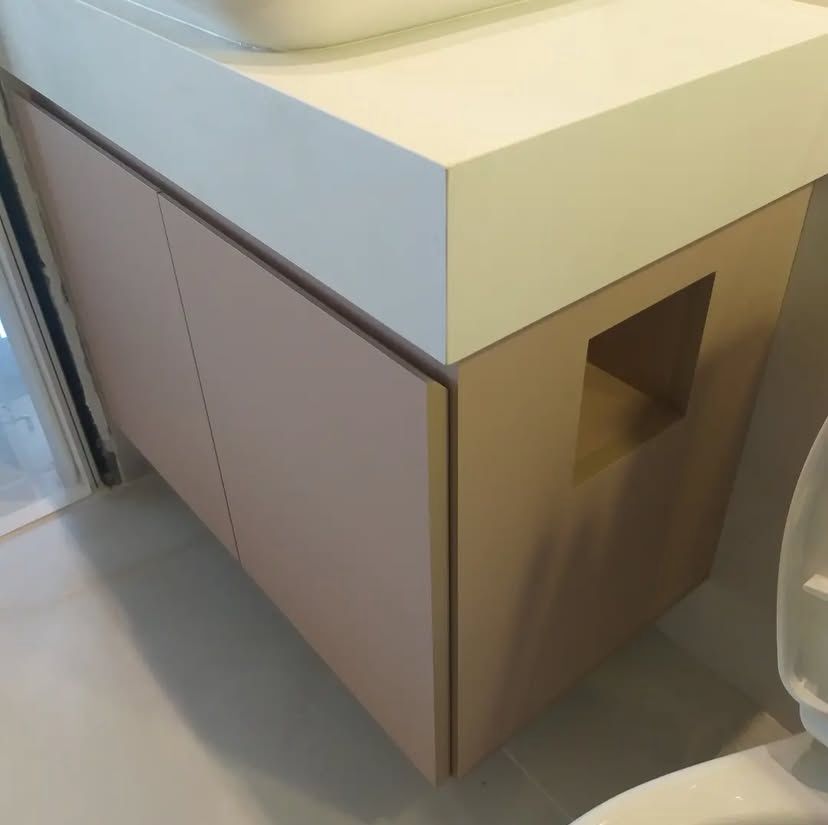 Banheiro compacto com design inteligente, apresentando armários suspensos, espelho grande e iluminação eficiente para otimizar o espaço.